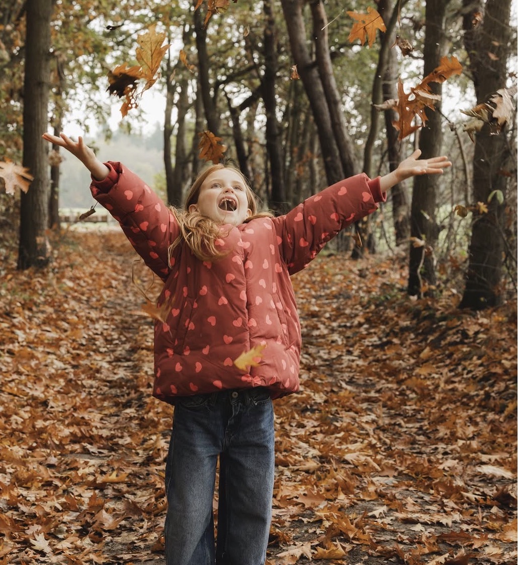 Kind speelt in de herfstbladeren